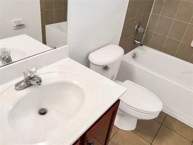 full bathroom with tile patterned flooring, vanity, tiled shower / bath combo, and toilet