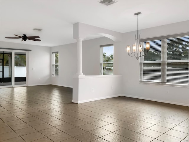 tiled empty room with ceiling fan with notable chandelier and ornate columns