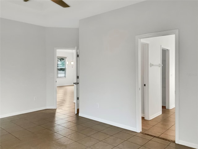 tiled empty room featuring ceiling fan