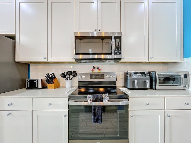 kitchen with white cabinetry, appliances with stainless steel finishes, and tasteful backsplash