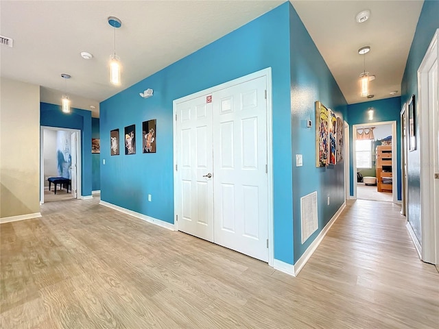 corridor with light hardwood / wood-style floors