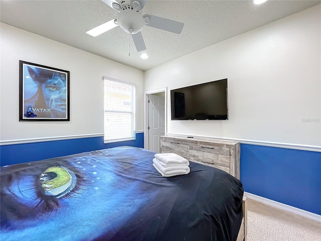 bedroom featuring ceiling fan, a textured ceiling, and carpet floors