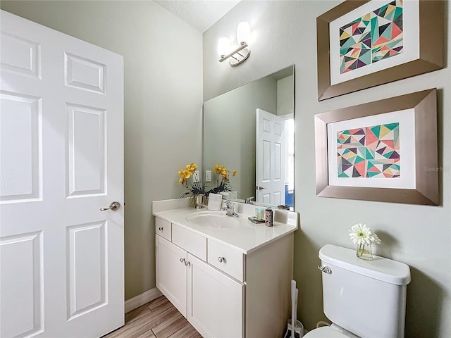 bathroom featuring a textured ceiling, toilet, and vanity