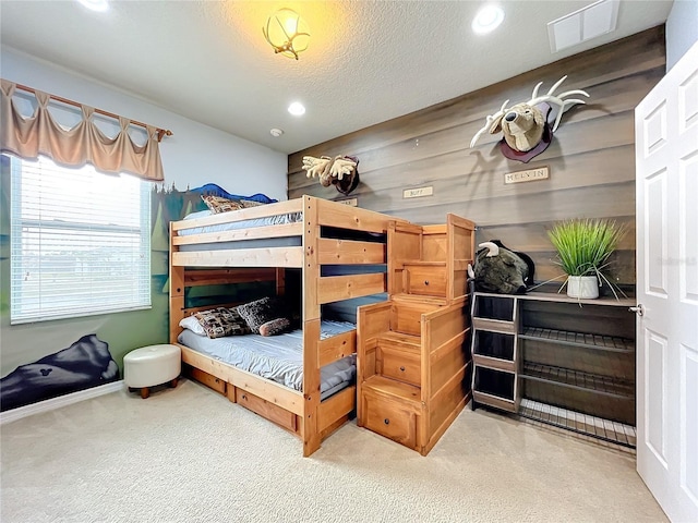 bedroom with a textured ceiling and wooden walls