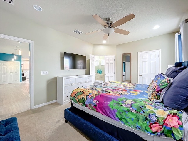 carpeted bedroom with ceiling fan and a textured ceiling