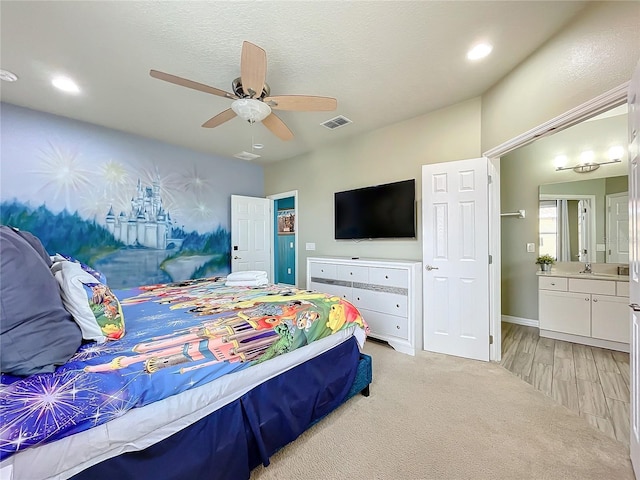 bedroom with ceiling fan, ensuite bathroom, and light wood-type flooring