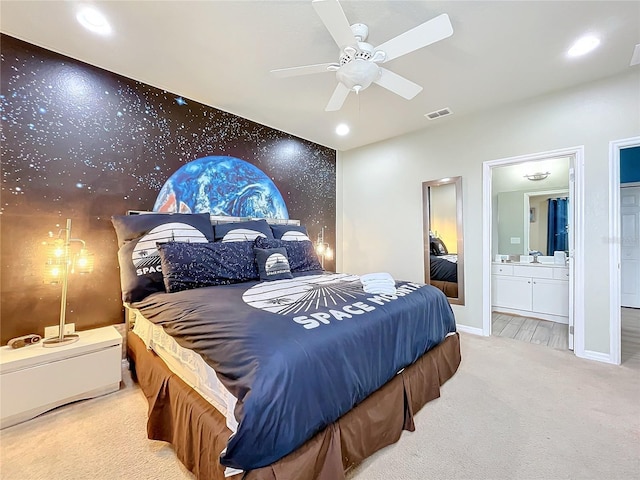 bedroom with sink, light colored carpet, ensuite bath, and ceiling fan