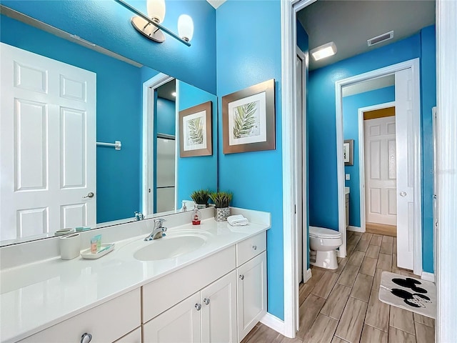 bathroom featuring toilet and vanity