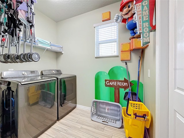 washroom with a textured ceiling and washing machine and dryer