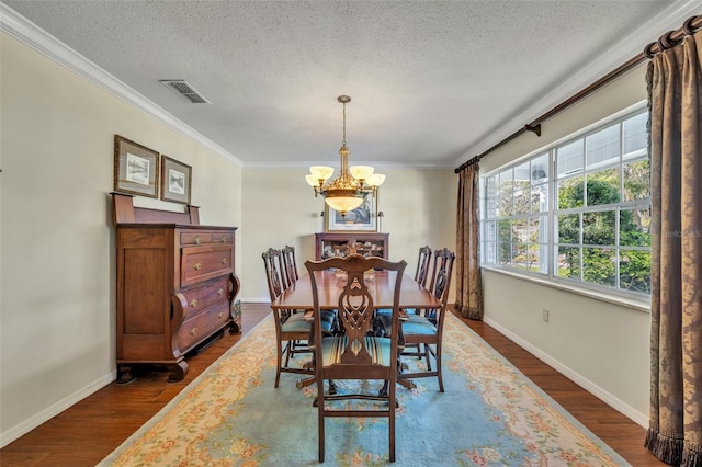 dining area with crown molding, dark hardwood / wood-style flooring, a chandelier, and a textured ceiling