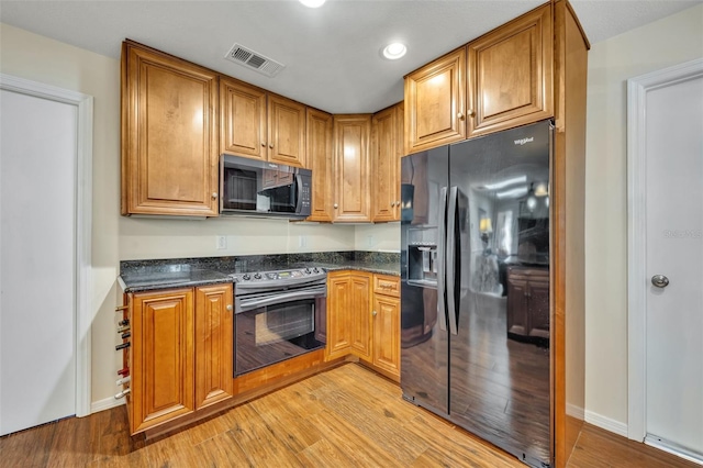 kitchen featuring black appliances and light hardwood / wood-style floors