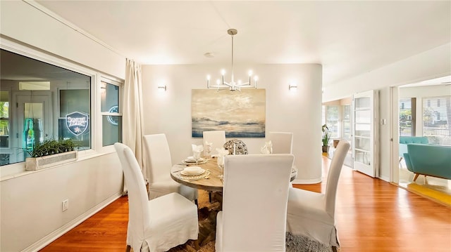 105 17th Ave NE, Saint Petersburg, FL 33704 - dining area featuring wood finished floors, baseboards, and an inviting chandelier