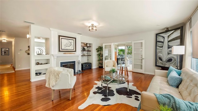 105 17th Ave NE, Saint Petersburg, FL 33704 - living room with baseboards, a glass covered fireplace, wood finished floors, and visible vents