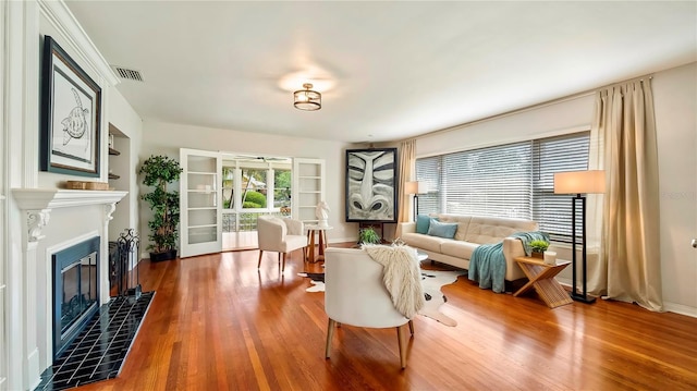 105 17th Ave NE, Saint Petersburg, FL 33704 - living room featuring a tile fireplace, built in features, wood finished floors, and visible vents