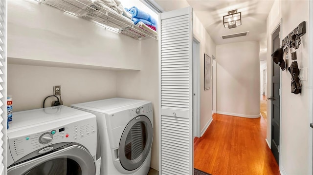 105 17th Ave NE, Saint Petersburg, FL 33704 - clothes washing area with light wood-type flooring, laundry area, washing machine and dryer, baseboards, and visible vents
