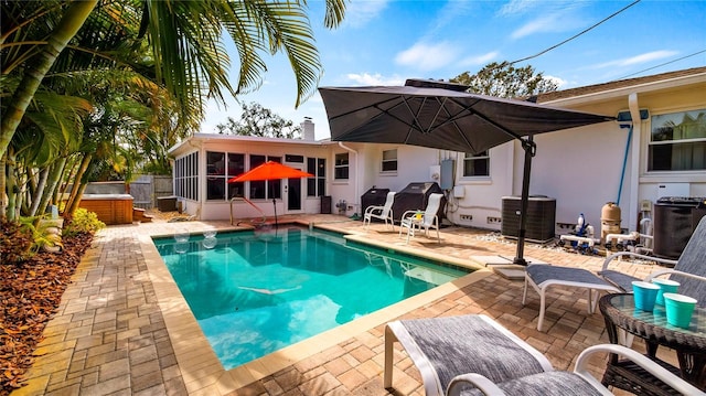 105 17th Ave NE, Saint Petersburg, FL 33704 - pool featuring fence, central air condition unit, a patio, a sunroom, and a hot tub