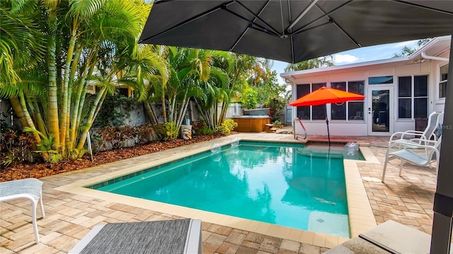 105 17th Ave NE, Saint Petersburg, FL 33704 - view of swimming pool featuring a fenced in pool, a sunroom, a hot tub, and a patio