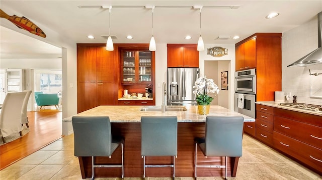 105 17th Ave NE, Saint Petersburg, FL 33704 - kitchen featuring a breakfast bar area, appliances with stainless steel finishes, wall chimney range hood, and a sink