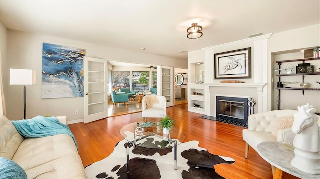 105 17th Ave NE, Saint Petersburg, FL 33704 - living area with wood finished floors, a fireplace with flush hearth, french doors, baseboards, and visible vents