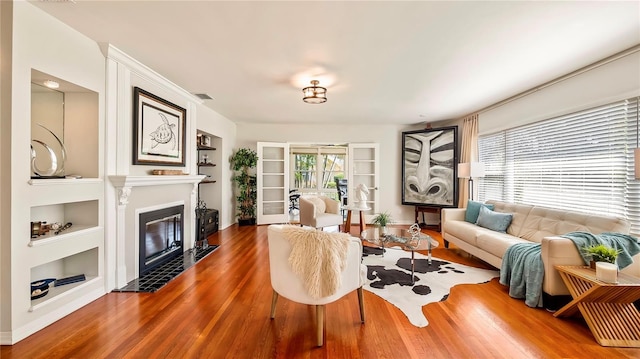 105 17th Ave NE, Saint Petersburg, FL 33704 - living area featuring visible vents, baseboards, built in shelves, wood finished floors, and a fireplace