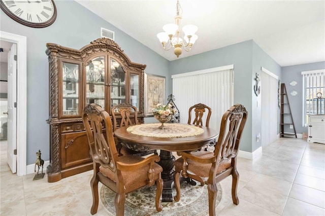 dining room featuring light tile patterned floors, lofted ceiling, and an inviting chandelier