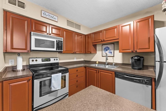 kitchen featuring sink, stainless steel appliances, and a textured ceiling