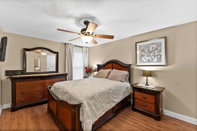 bedroom featuring hardwood / wood-style floors, a textured ceiling, and ceiling fan