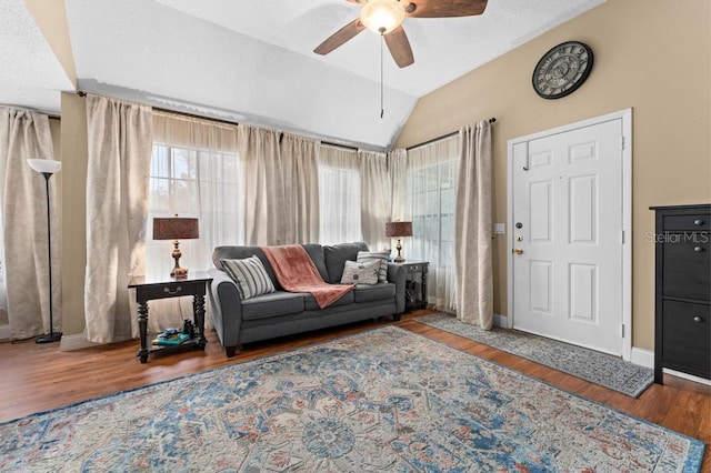 living room featuring hardwood / wood-style flooring, vaulted ceiling, and ceiling fan