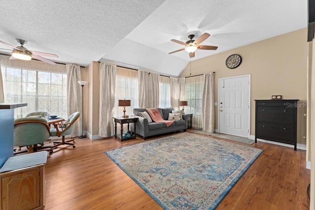 living room featuring ceiling fan, lofted ceiling, a healthy amount of sunlight, and a textured ceiling