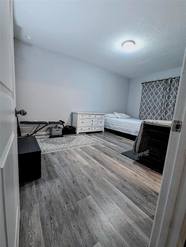 bedroom featuring hardwood / wood-style flooring and a textured ceiling