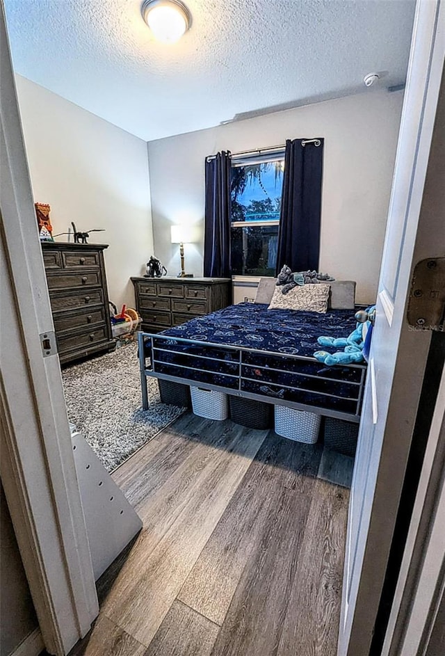 bedroom with a textured ceiling and hardwood / wood-style floors