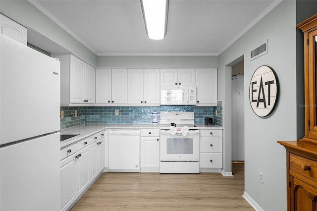 3655 Scenic Highway 98 Unit 503B, Destin, FL 32541 - kitchen with white appliances, light countertops, decorative backsplash, white cabinets, and ornamental molding