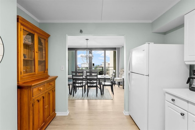3655 Scenic Highway 98 Unit 503B, Destin, FL 32541 - kitchen with freestanding refrigerator, light wood finished floors, crown molding, light countertops, and a chandelier