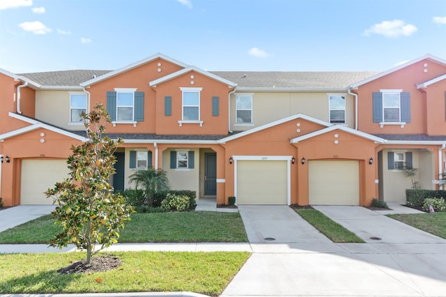 multi unit property featuring a garage and a front yard