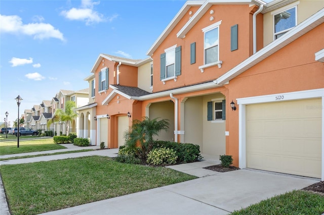 townhome / multi-family property with a garage and a front yard