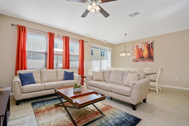 living room with ceiling fan with notable chandelier and light tile patterned flooring