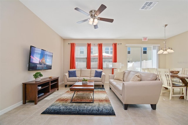 living room featuring light tile patterned flooring and ceiling fan with notable chandelier