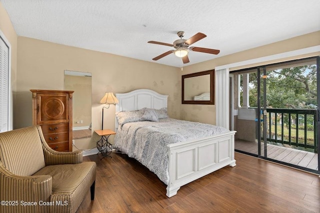 bedroom featuring access to exterior, ceiling fan, dark hardwood / wood-style floors, and a textured ceiling