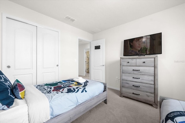 bedroom with light colored carpet and a closet