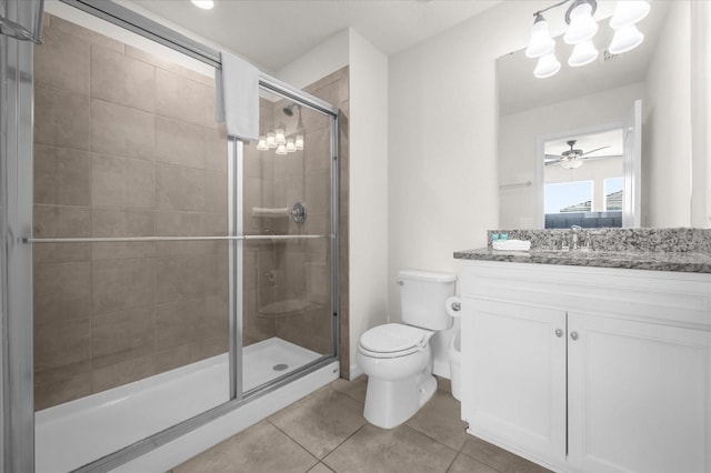 bathroom with vanity, tile patterned floors, a shower with door, and toilet