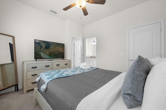 carpeted bedroom with ceiling fan and ensuite bath