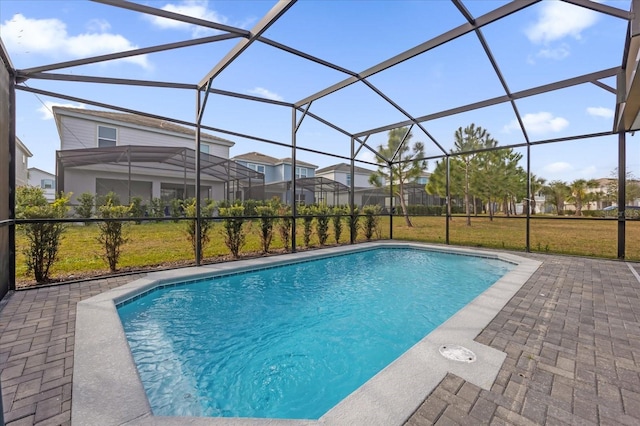 view of swimming pool featuring a lanai, a patio, and a lawn