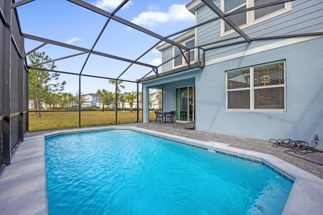 view of swimming pool with a yard, glass enclosure, and a patio area