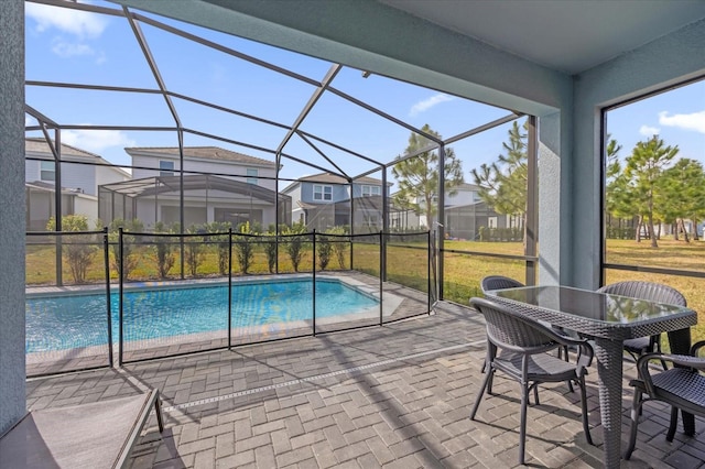 view of pool featuring a yard, a patio area, and glass enclosure