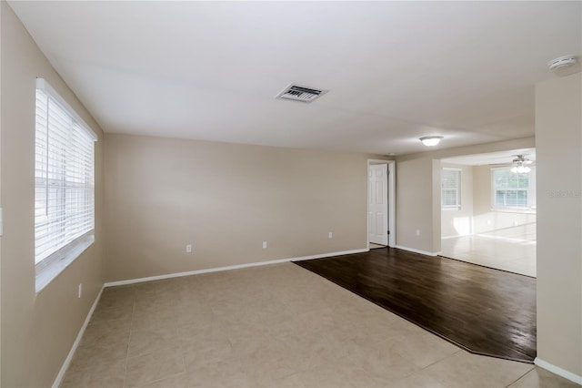 tiled spare room with ceiling fan and a healthy amount of sunlight