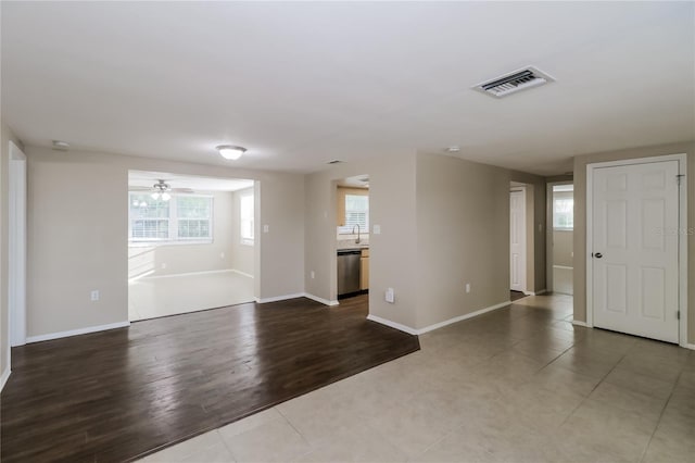 unfurnished room featuring sink, light wood-type flooring, and ceiling fan