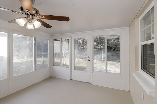 unfurnished sunroom with ceiling fan and plenty of natural light