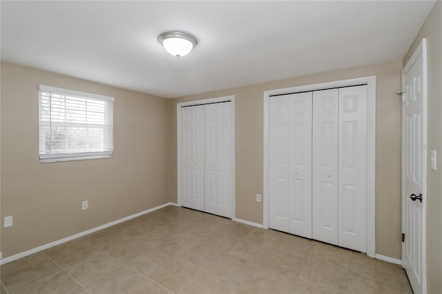 unfurnished bedroom featuring multiple closets