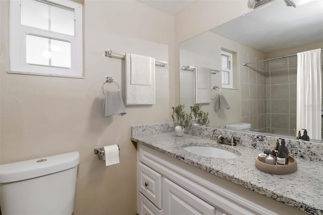 bathroom with vanity, toilet, and a tile shower