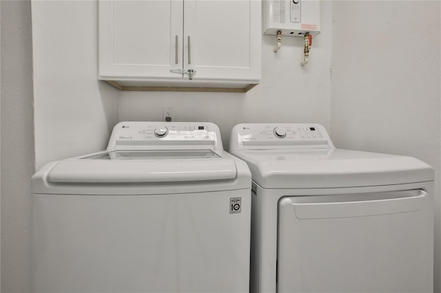 washroom featuring cabinets, independent washer and dryer, and water heater